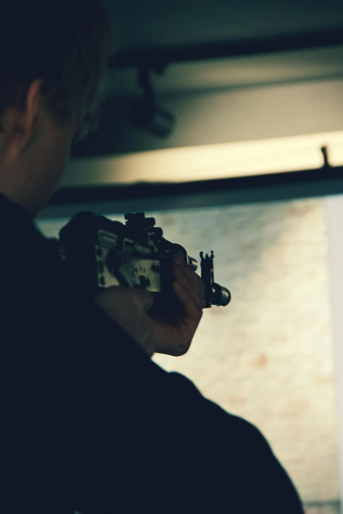 Person aiming a rifle at a target
